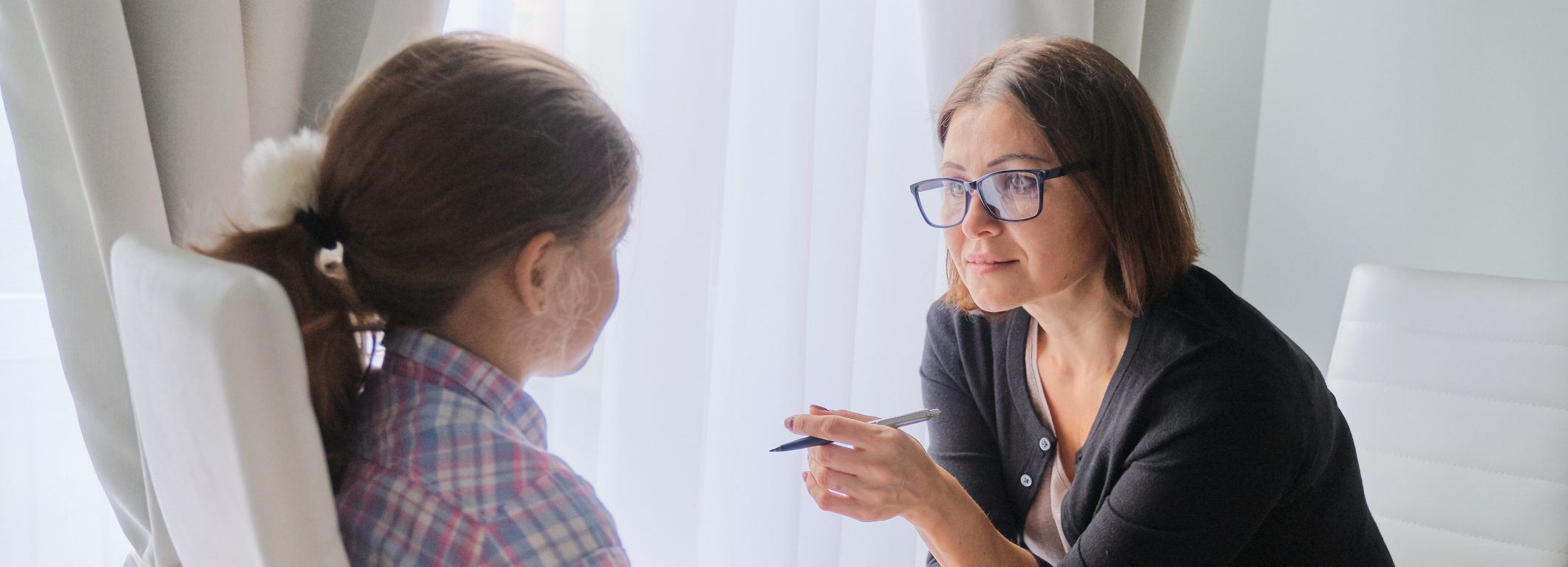 Woman social worker talking to girl. Child psychology, mental health